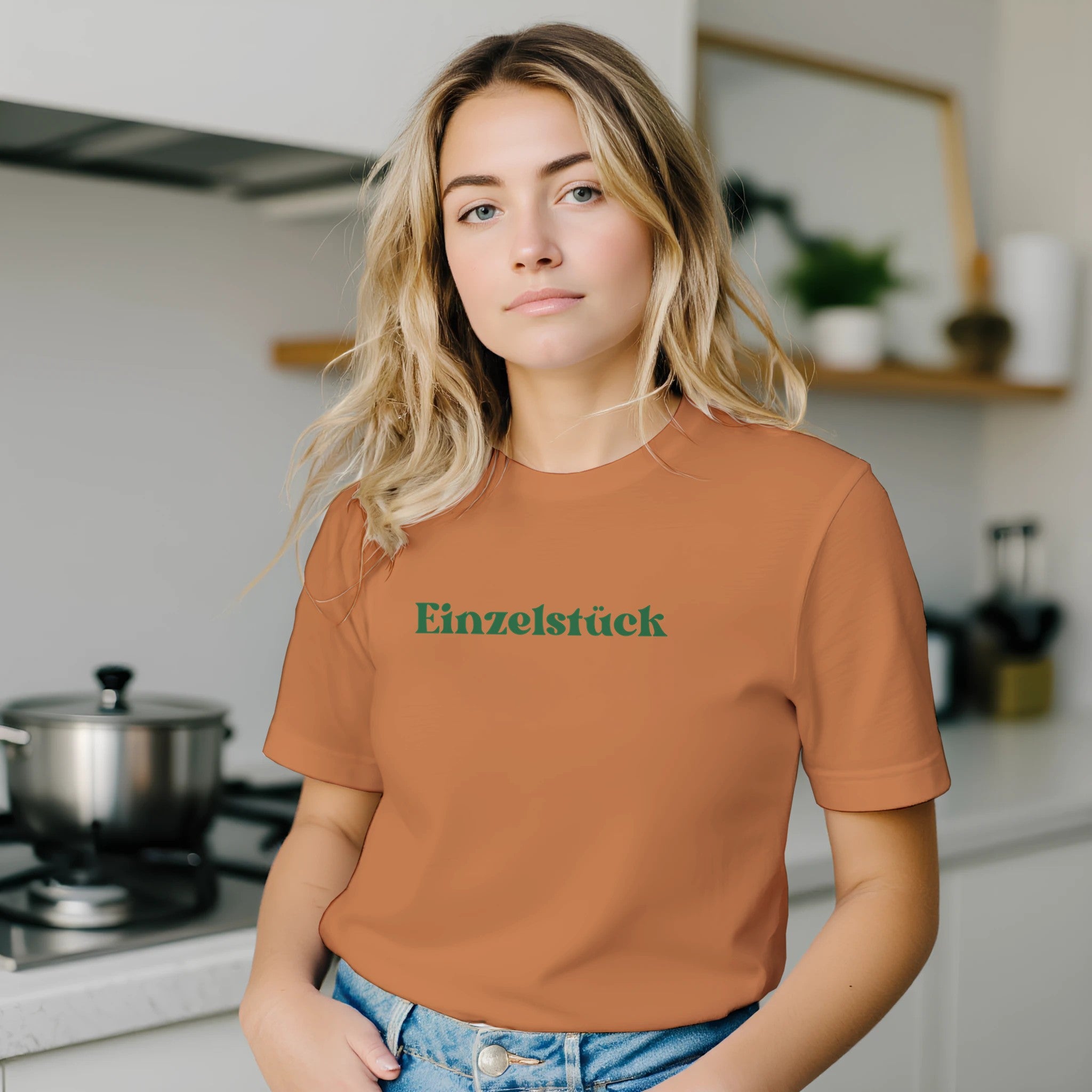 Unisex T-Shirt in gebranntem Orange aus hochwertiger Baumwolle mit grünem „Einzelstück“- Schriftzug, nachhaltig und.